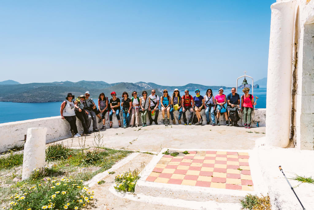 Gruppo di escursionisti davanti a una terrazza con vista panoramica sul mare, trekking in Grecia, Piccole Cicladi.